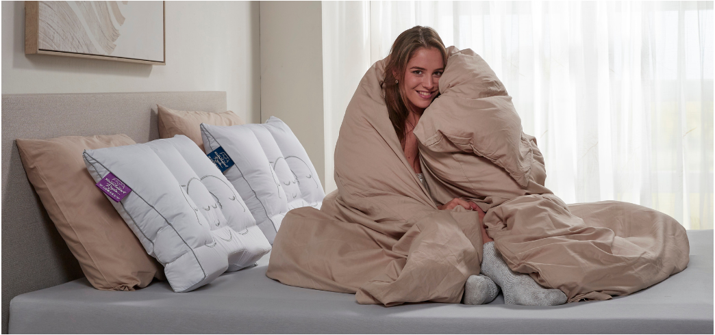 Dame op bed gewikkeld in dekbed