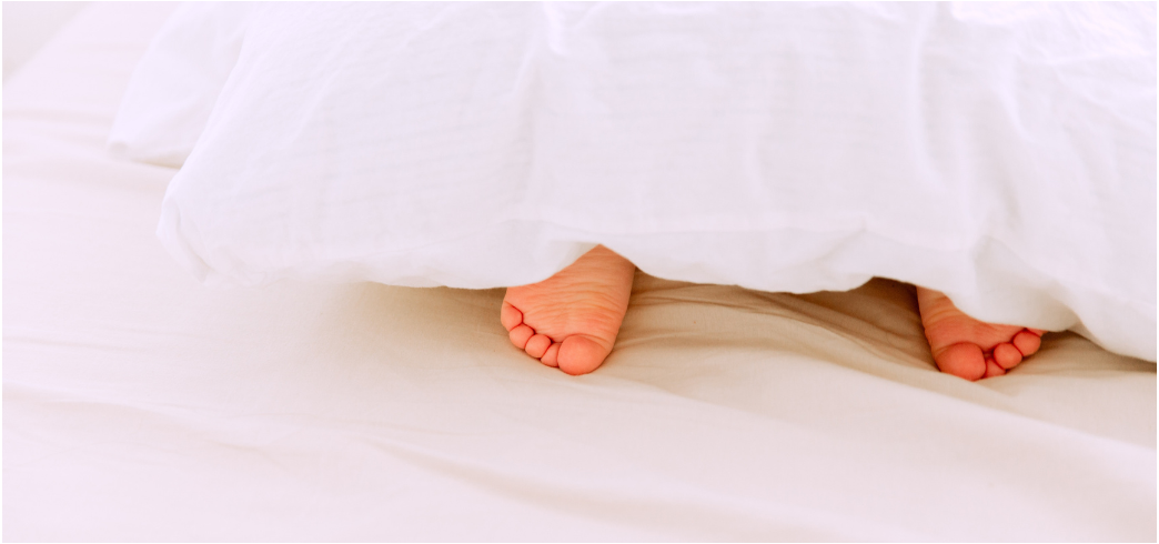 Kindje onder lakens in bed